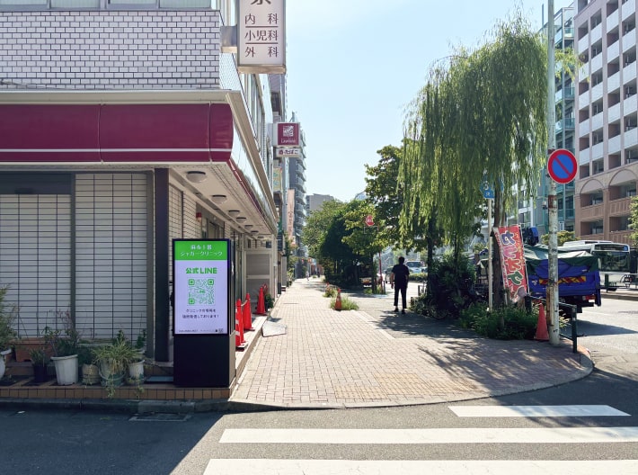出口を出たら左方向へ直進します。道路沿いに飲食店や建物が並ぶ通りです。